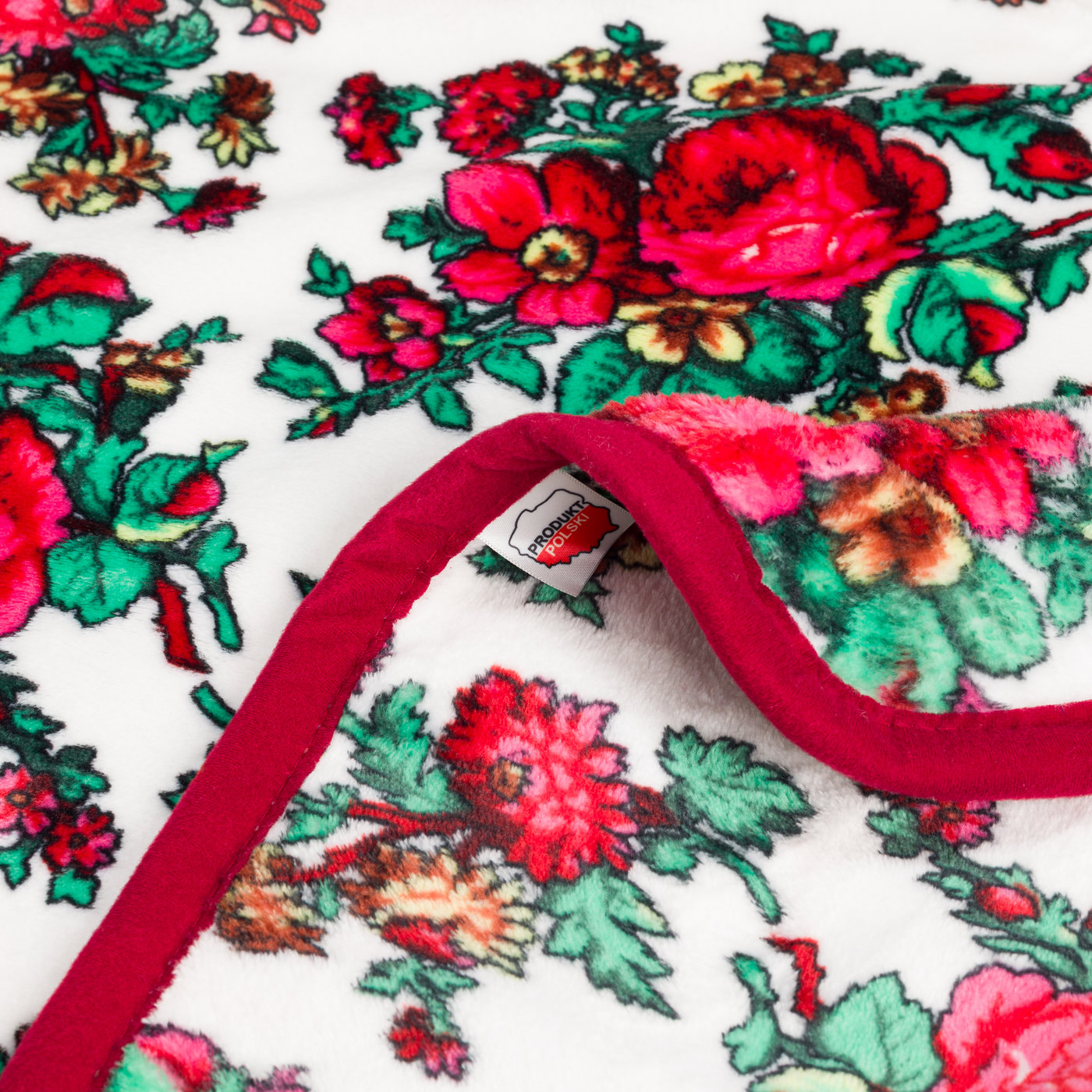 Zbliżenie wzór kwiatowy folklorowy czerwone kwiaty metka Produkt Polski bordowy brzeg